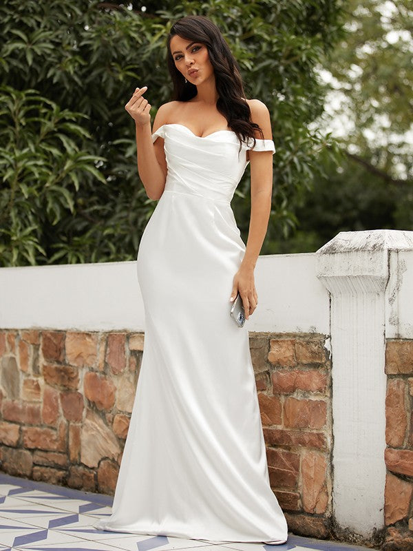 Elegant white sheath wedding dress with off-the-shoulder neckline and ruched bodice.