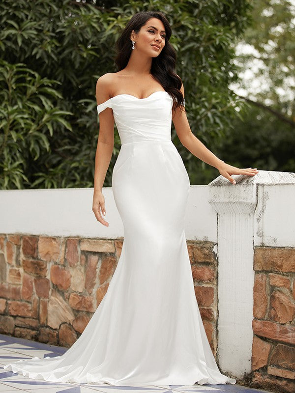 Close-up of the ruched off-the-shoulder neckline on the satin wedding dress.