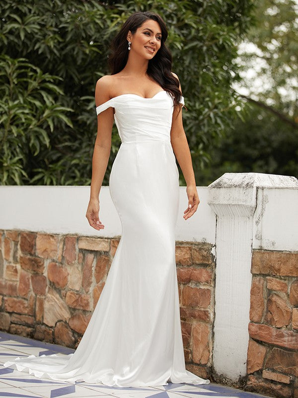 Side profile of the elegant sheath wedding dress with a flowing sweep train.