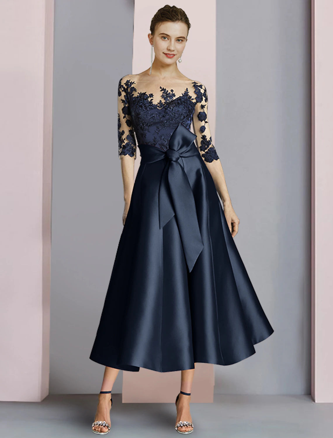 Woman wearing an elegant Weitese sheath mother of the bride dress with half sleeves and scoop neck.