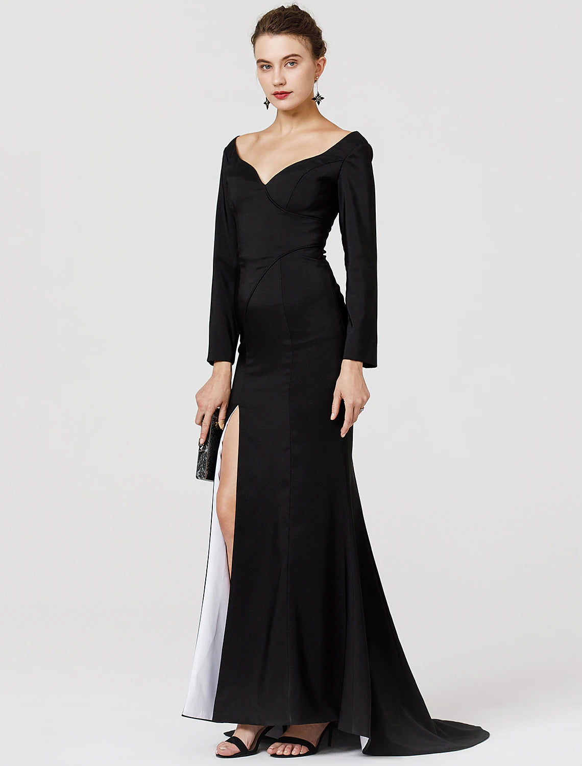 Woman in a dark, long-sleeved, V-neck stretch satin prom dress with a split front.