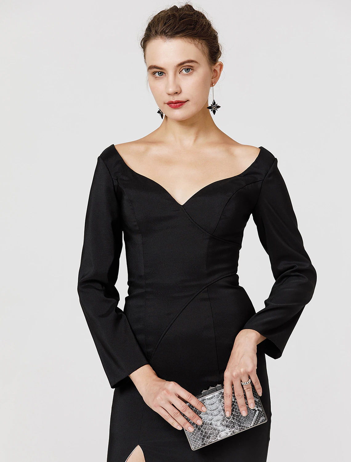 Woman posing in a dark stretch satin prom dress, showcasing the split front.