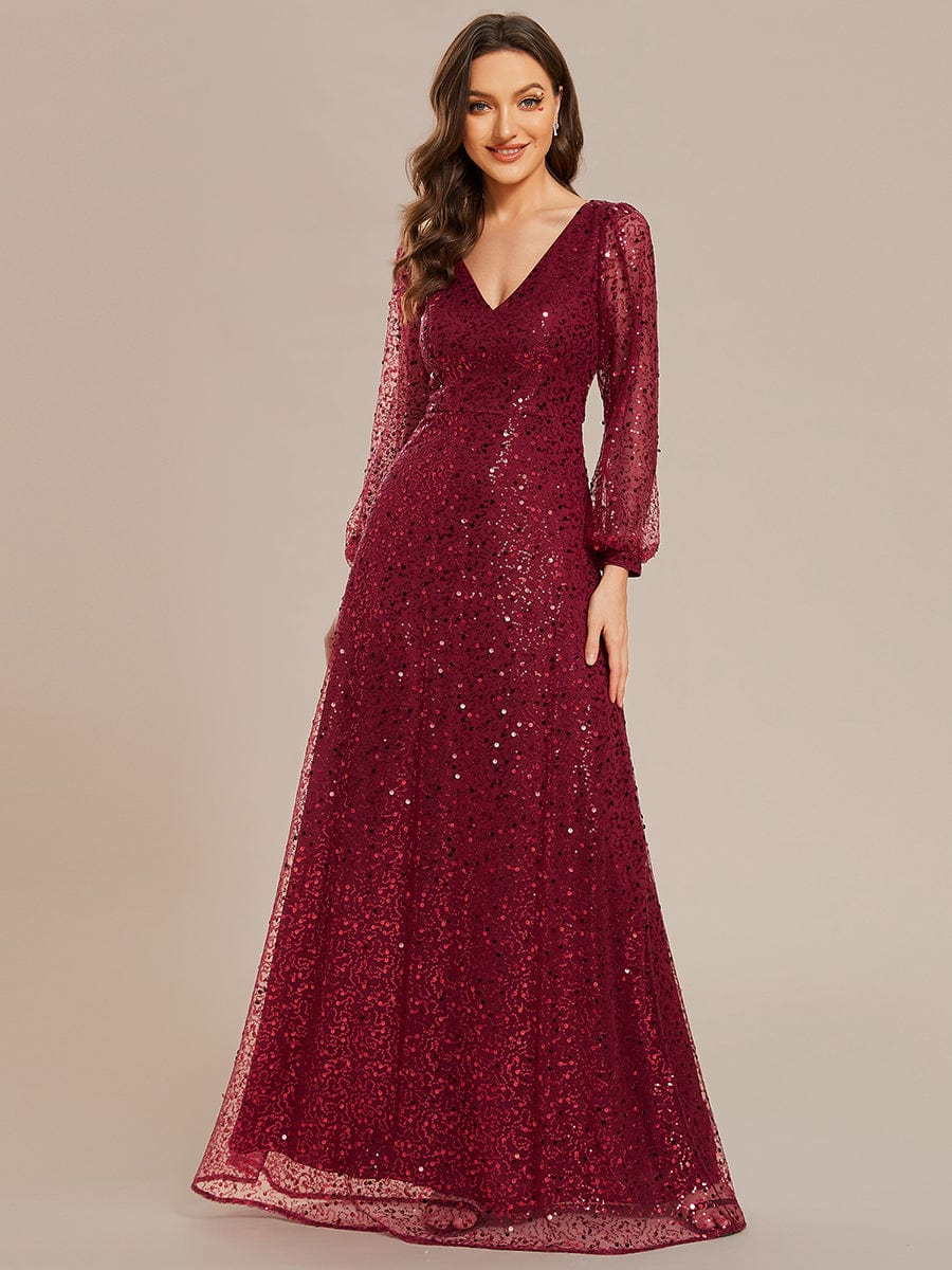 Full-length view of a woman in a red shimmering sequin A-line evening dress.