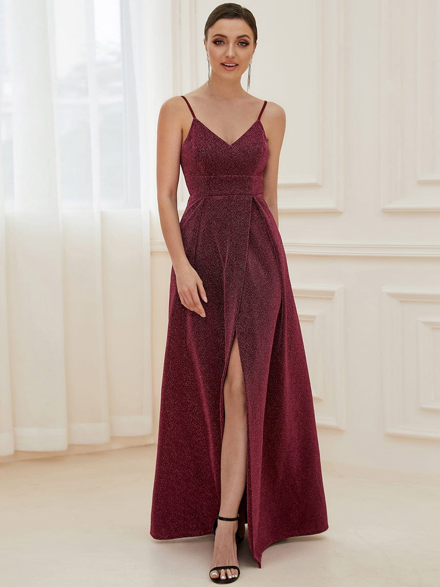 Model wearing a shiny red spaghetti strap evening dress with a front slit.