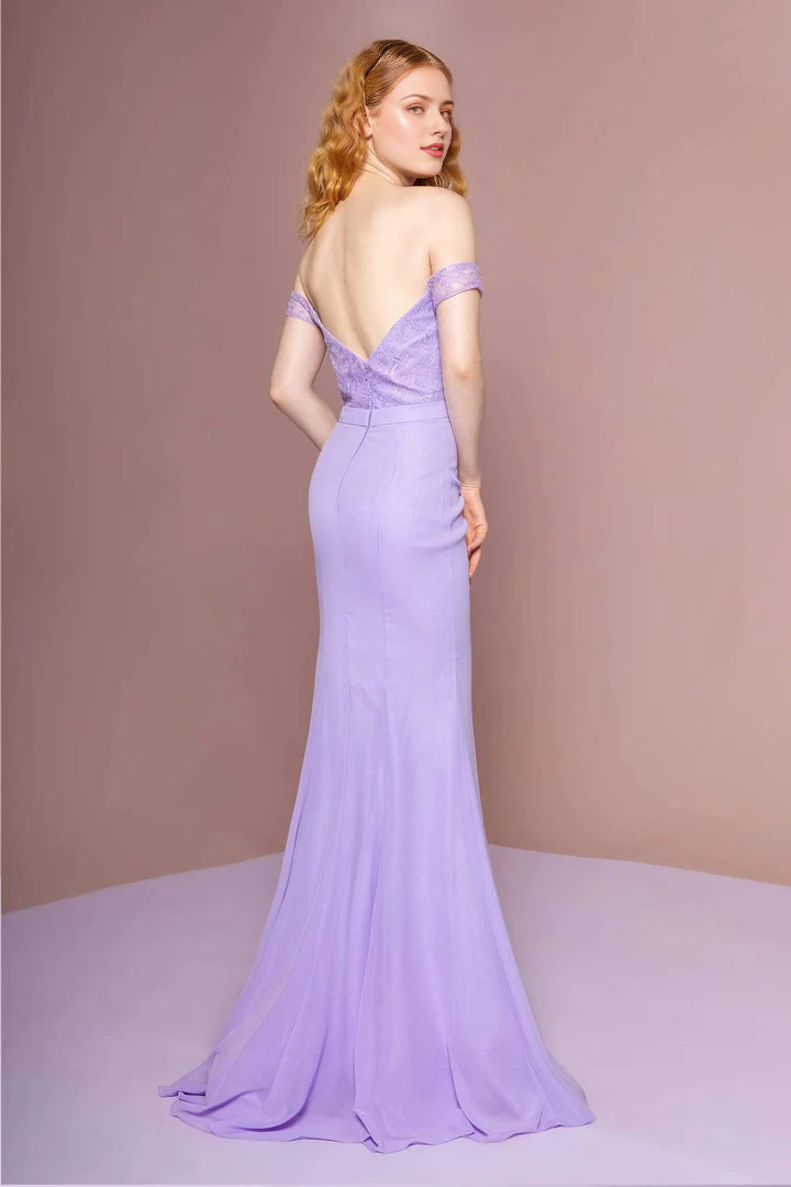 Side view of a woman posing in the long shoulder lace mermaid gown.