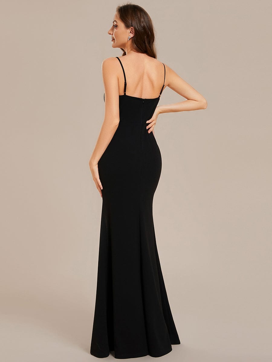 Side view of a model in a black bodycon dress, showing the high slit detail.