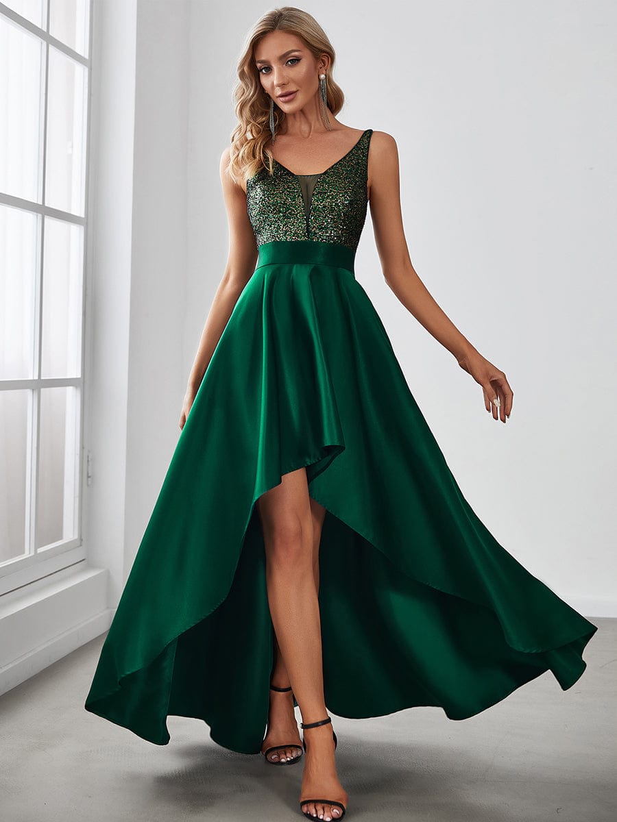 Woman in dark green sparkly bodice high-low prom dress.