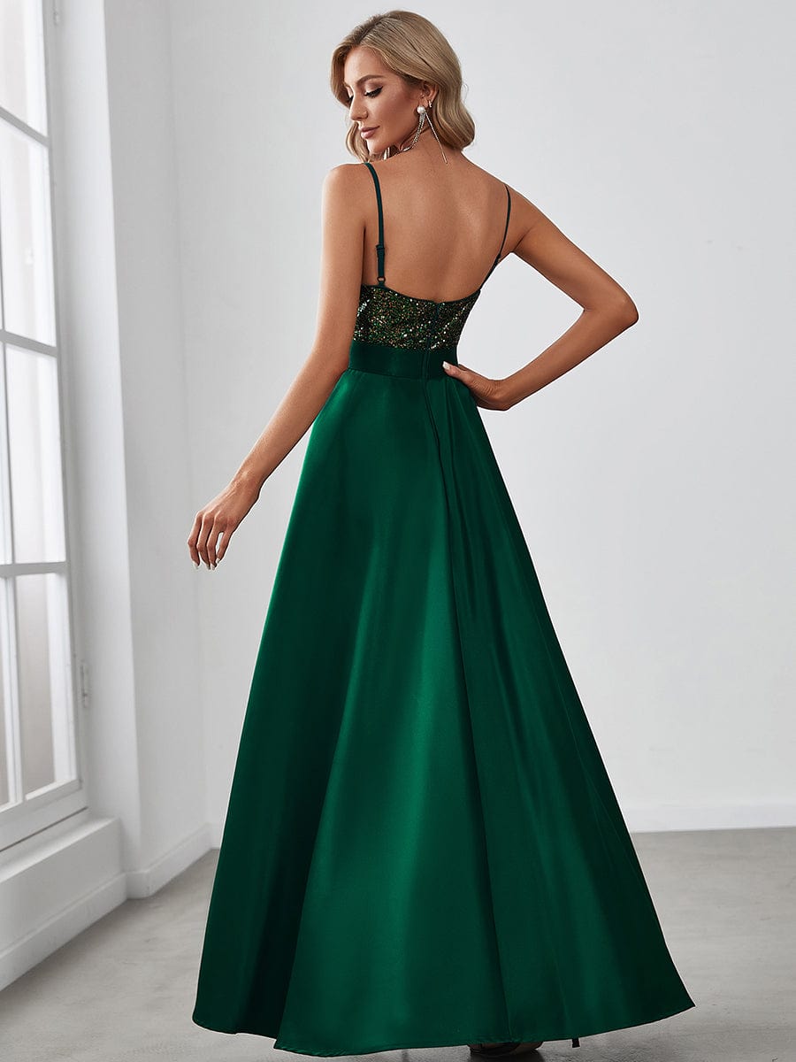 Side view of woman in dark green sparkly high-low prom dress.