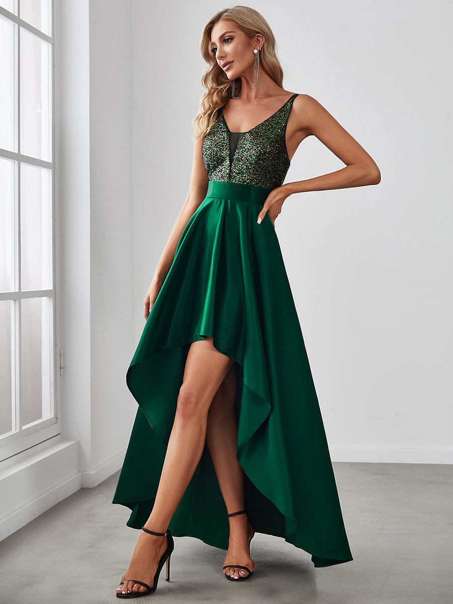 Back view of woman in dark green sparkly high-low prom dress.