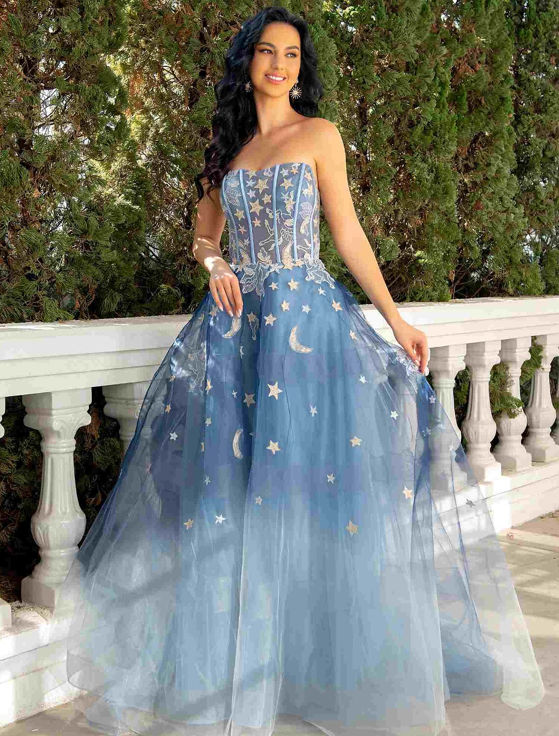 Model wearing a strapless ball gown with lace and sequin appliques, front view.