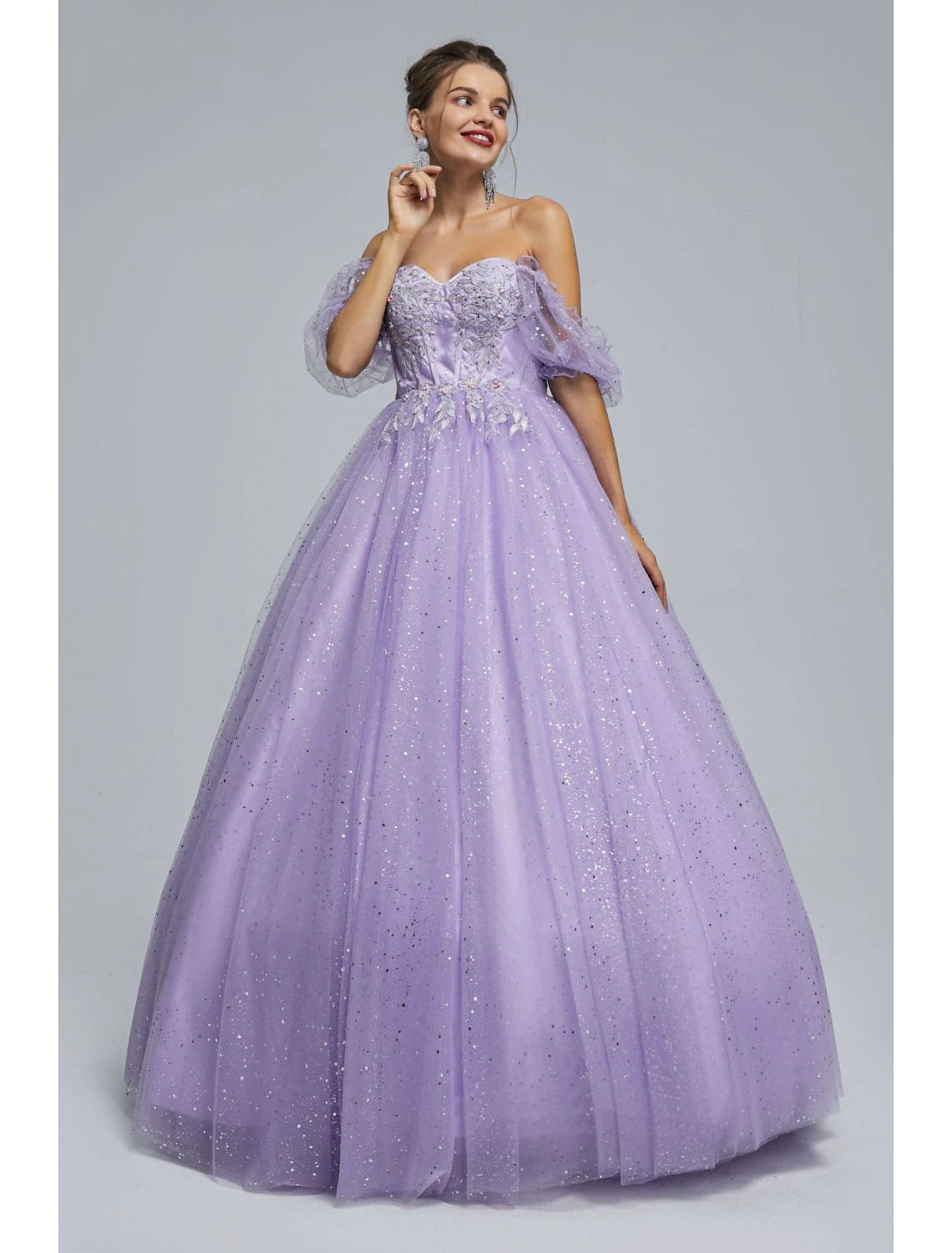 Woman wearing an elegant light blue ball gown with sweetheart neckline and short sleeves.