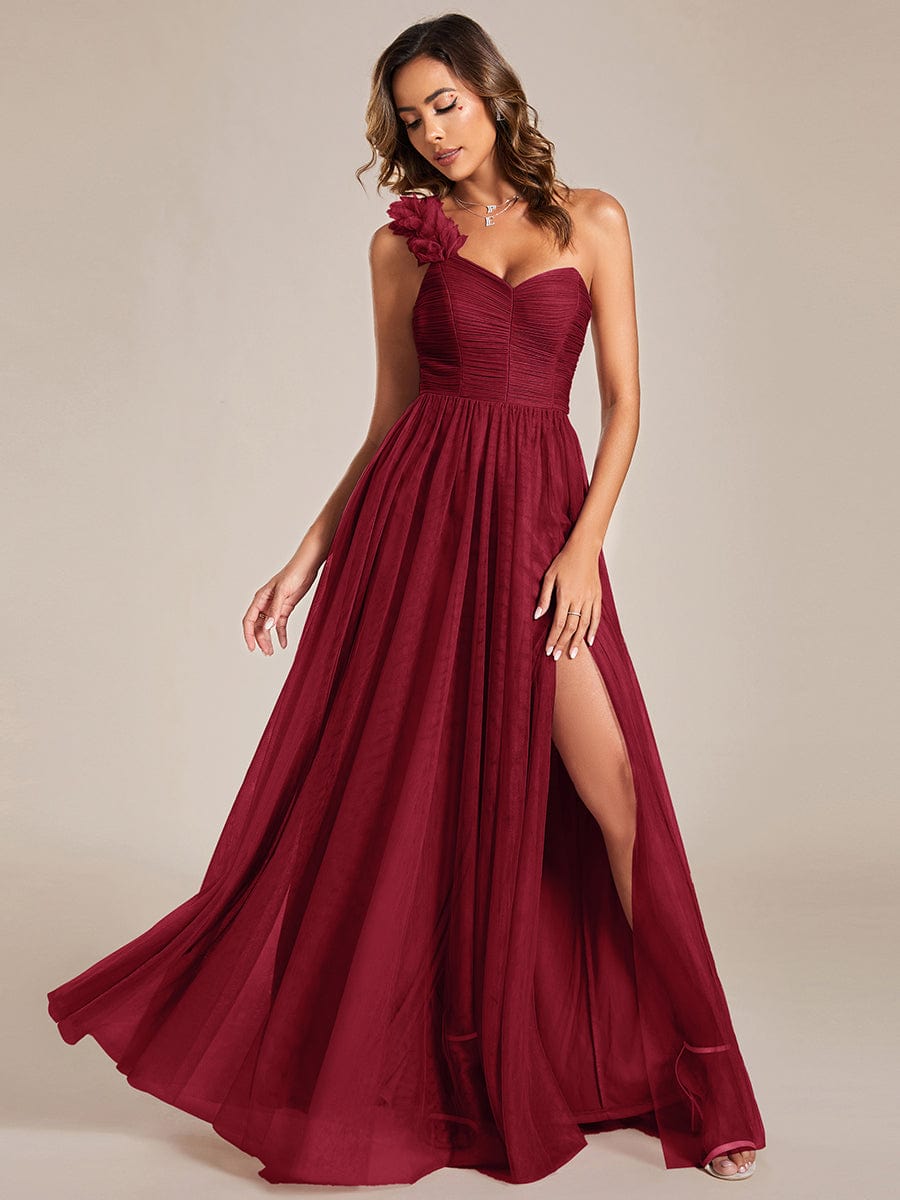 Model wearing a red Weitese sweetheart one-shoulder bridesmaid dress with floral tulle and a high slit.
