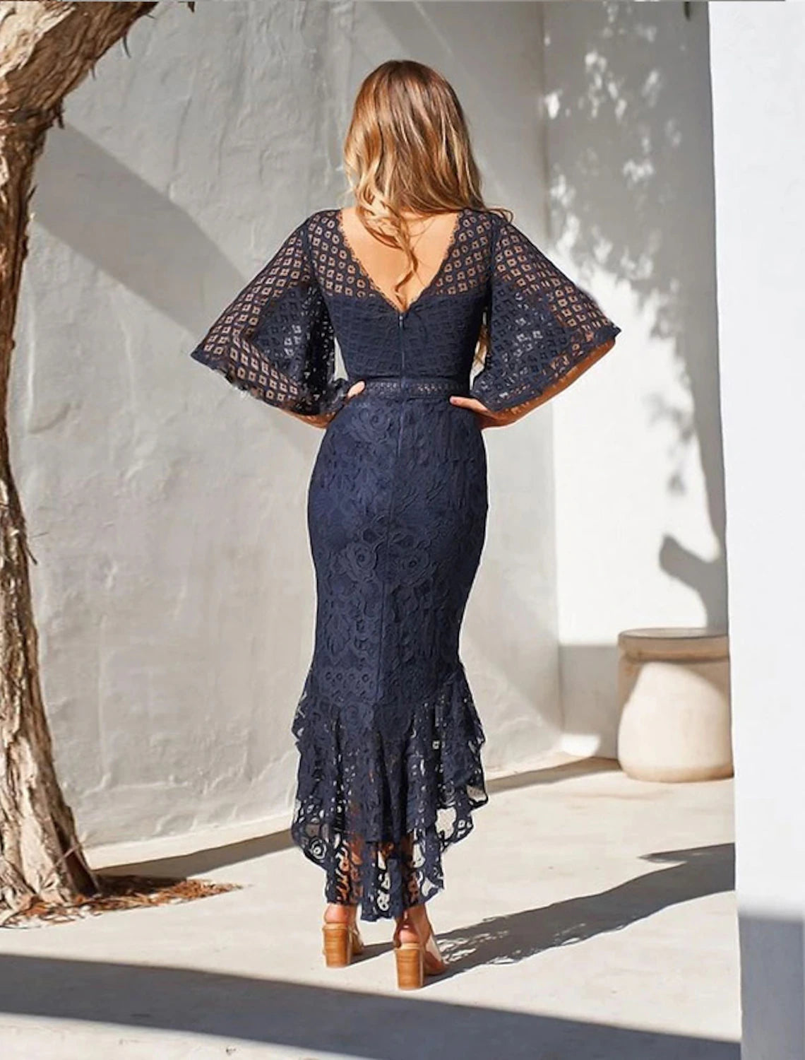Woman wearing a red wine lace midi sheath dress with sweetheart neckline.