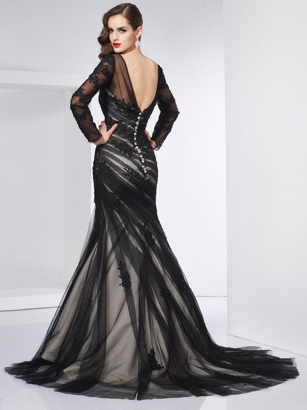 Back view of a long-sleeved trumpet mermaid dress, showcasing the net fabric and applique details.