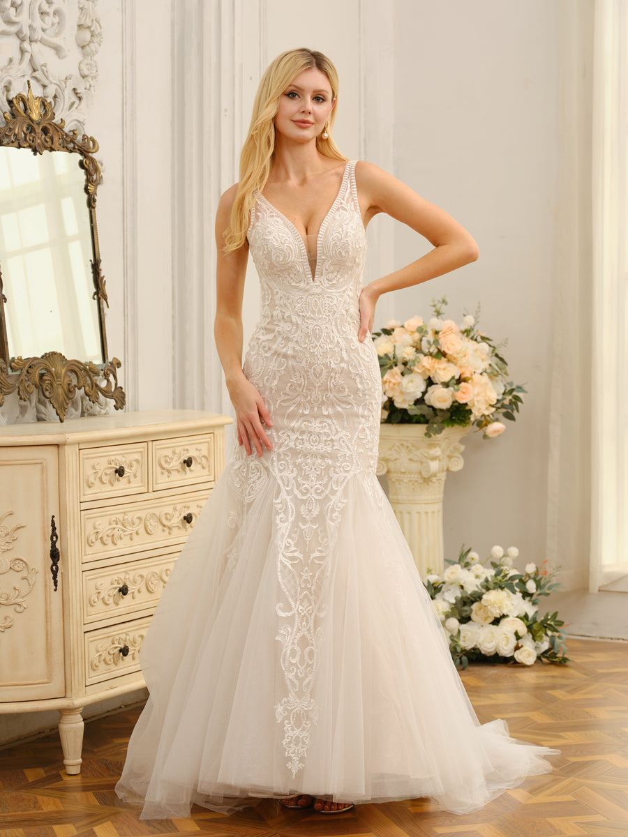 Model wearing a white trumpet mermaid wedding dress with a V-neck and appliques.