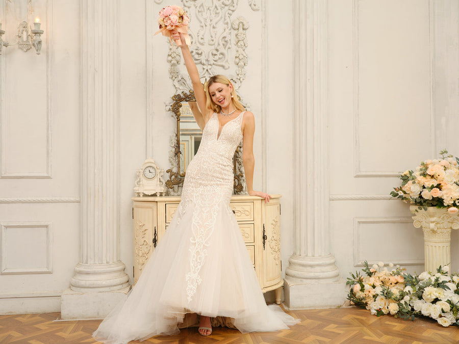 Close-up of the bodice and V-neckline of the white trumpet mermaid wedding dress with intricate appliques.