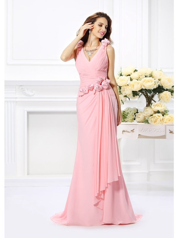 Model wearing a long V-neck trumpet mermaid chiffon bridesmaid dress with hand-made flower details.