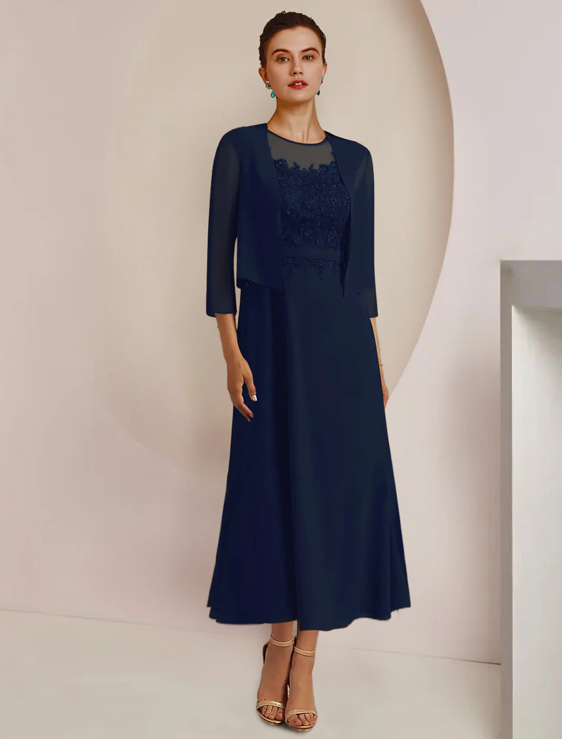 A woman wearing the elegant two-piece A-line mother of the bride dress with a lace jacket.