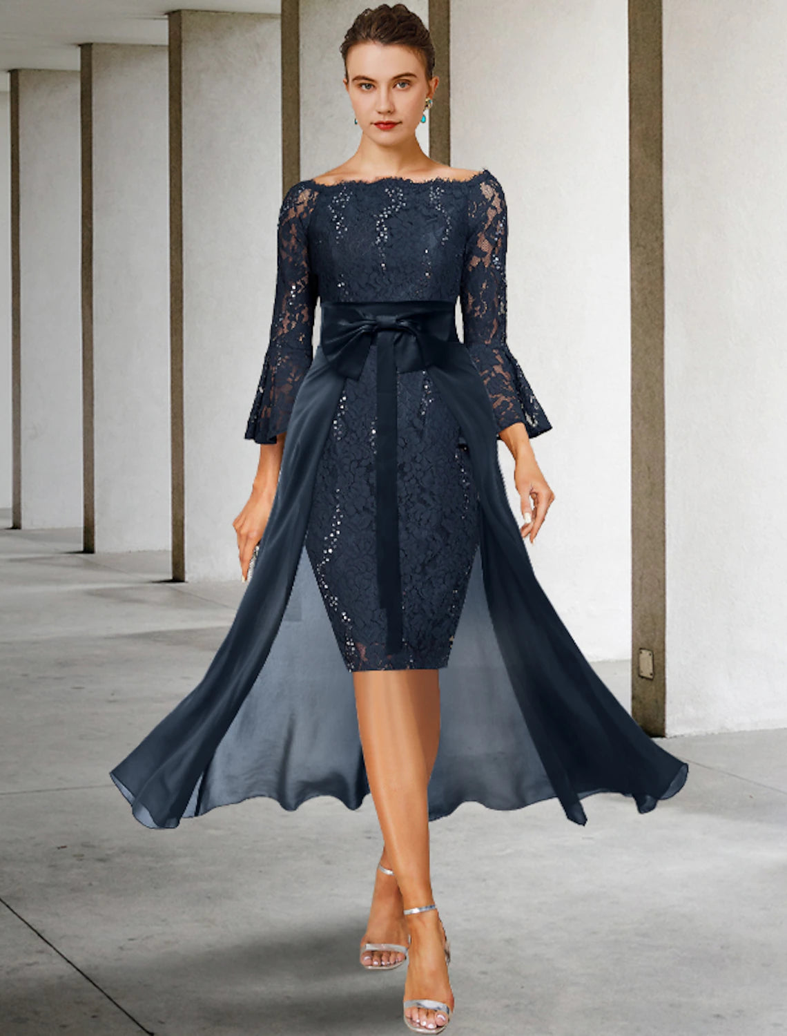 Woman wearing an elegant two-piece off-shoulder lace and chiffon mother of the bride dress.