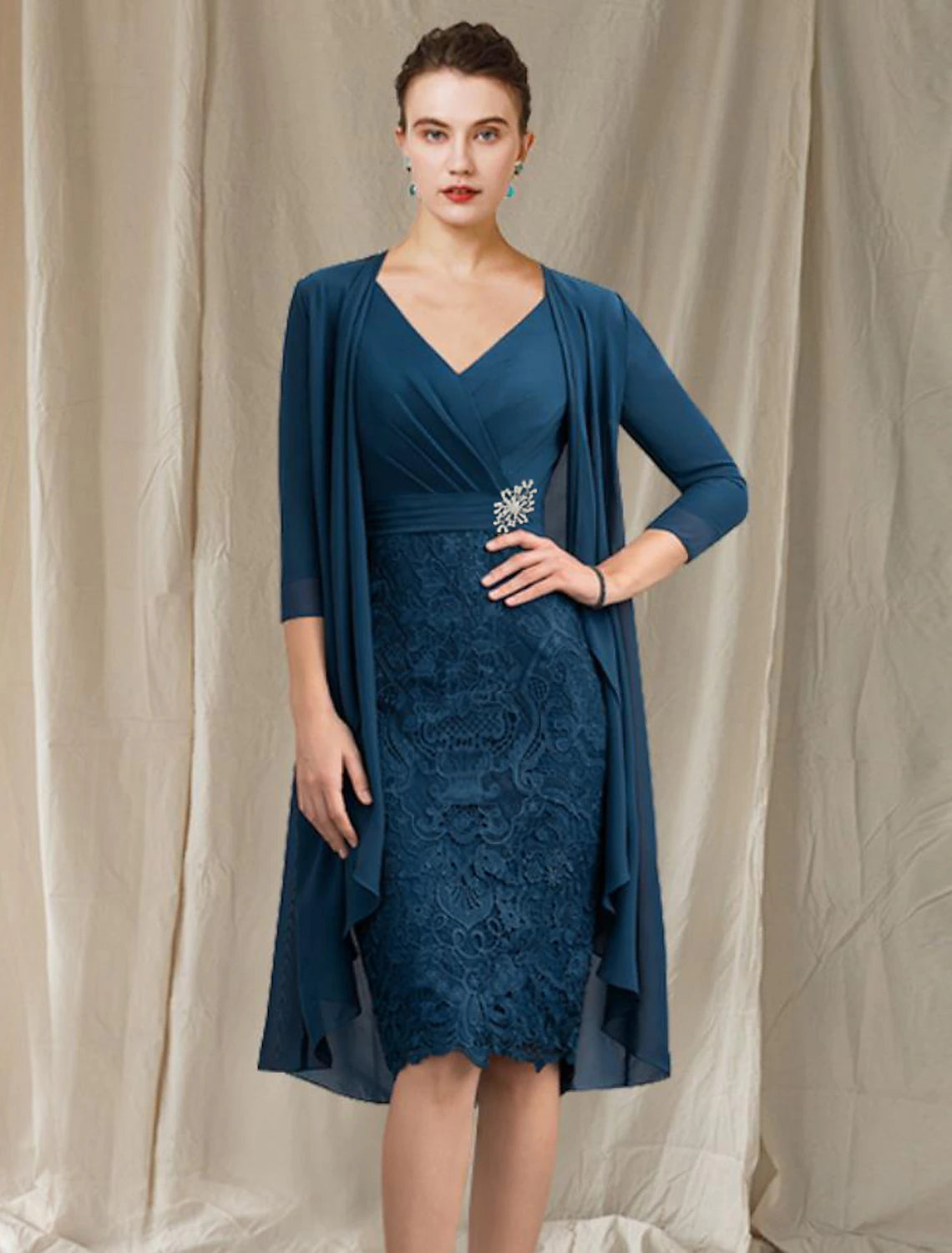 Woman wearing an elegant two-piece sheath Mother of the Bride dress with V-neck and half sleeves.