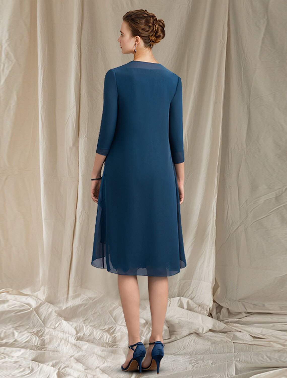 Side view of the two-piece knee-length Mother of the Bride dress.