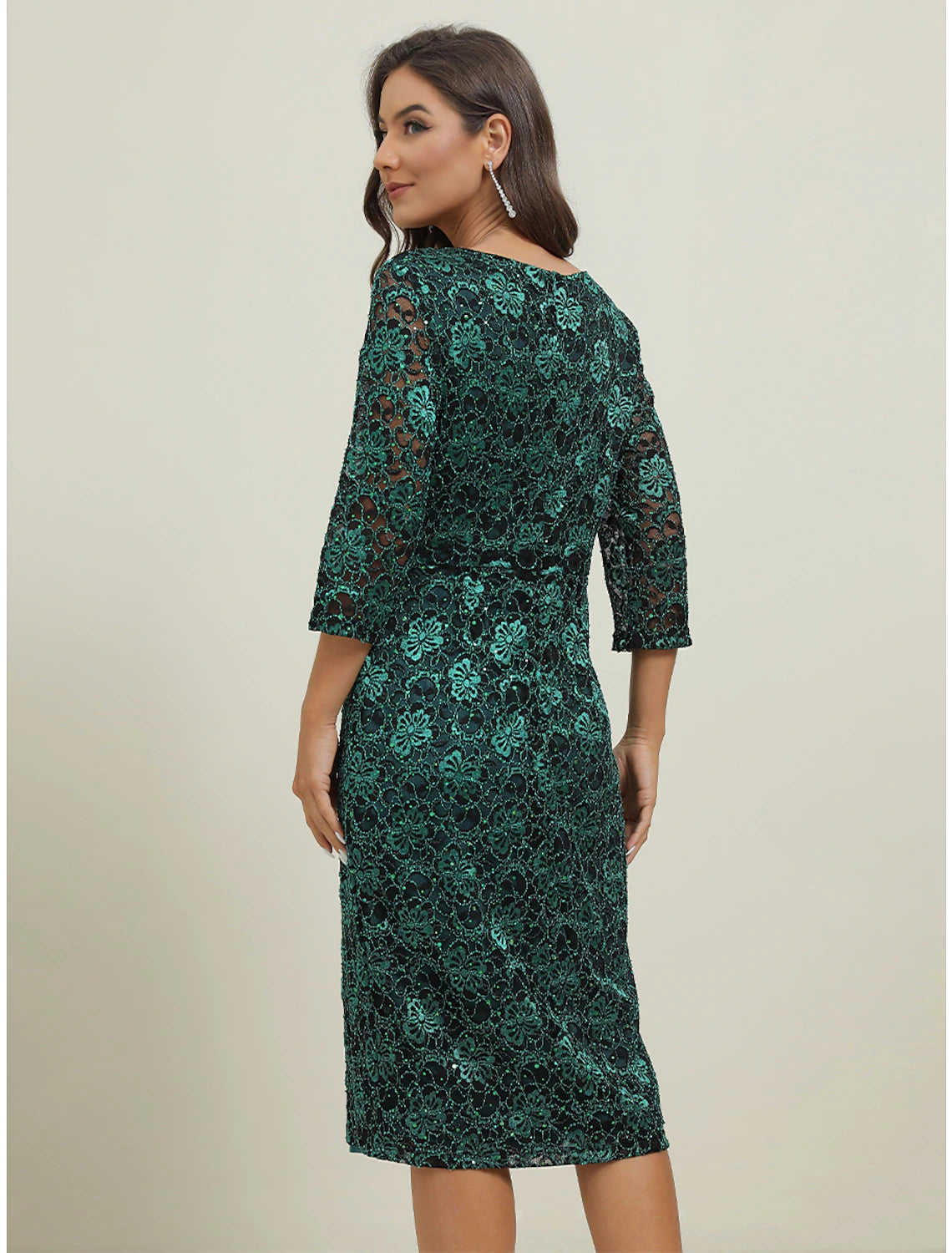 Side view of a woman in a green two-piece lace maxi dress, showcasing the silhouette.
