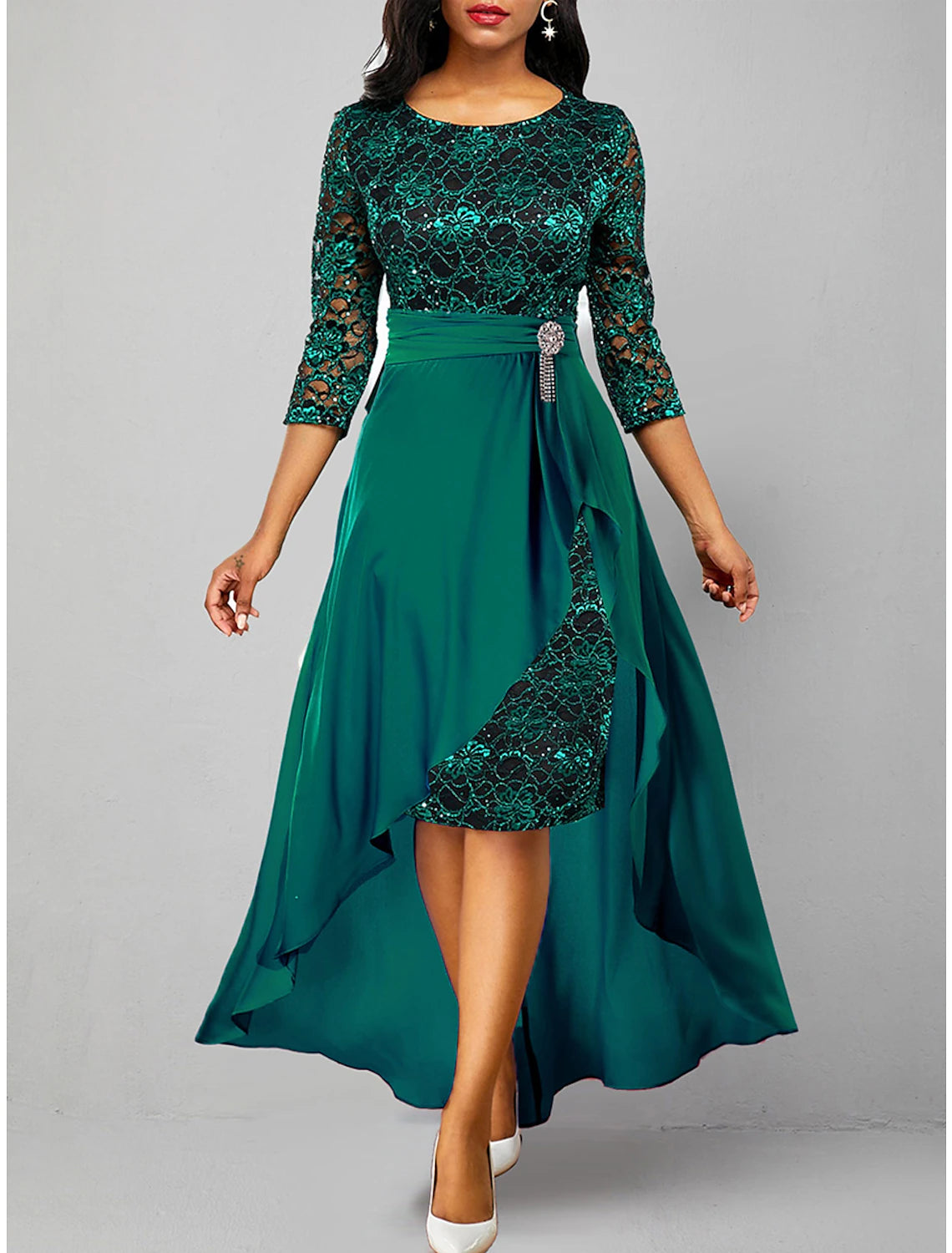 Full-length view of a woman walking in the green two-piece lace maxi dress.