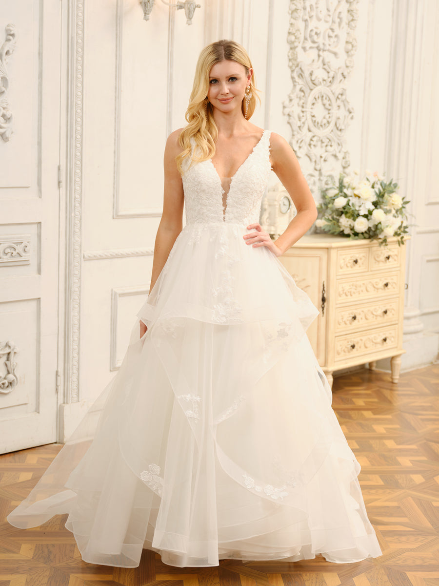 Model wearing a white V-neck ball gown wedding dress with intricate appliques.