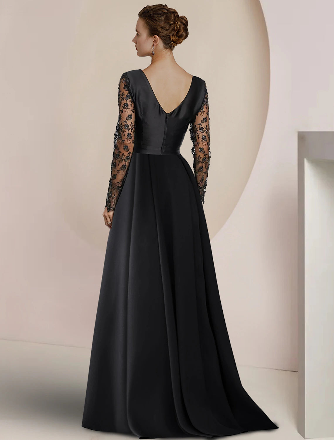 Side view of a woman in a formal floor-length dress with appliques.