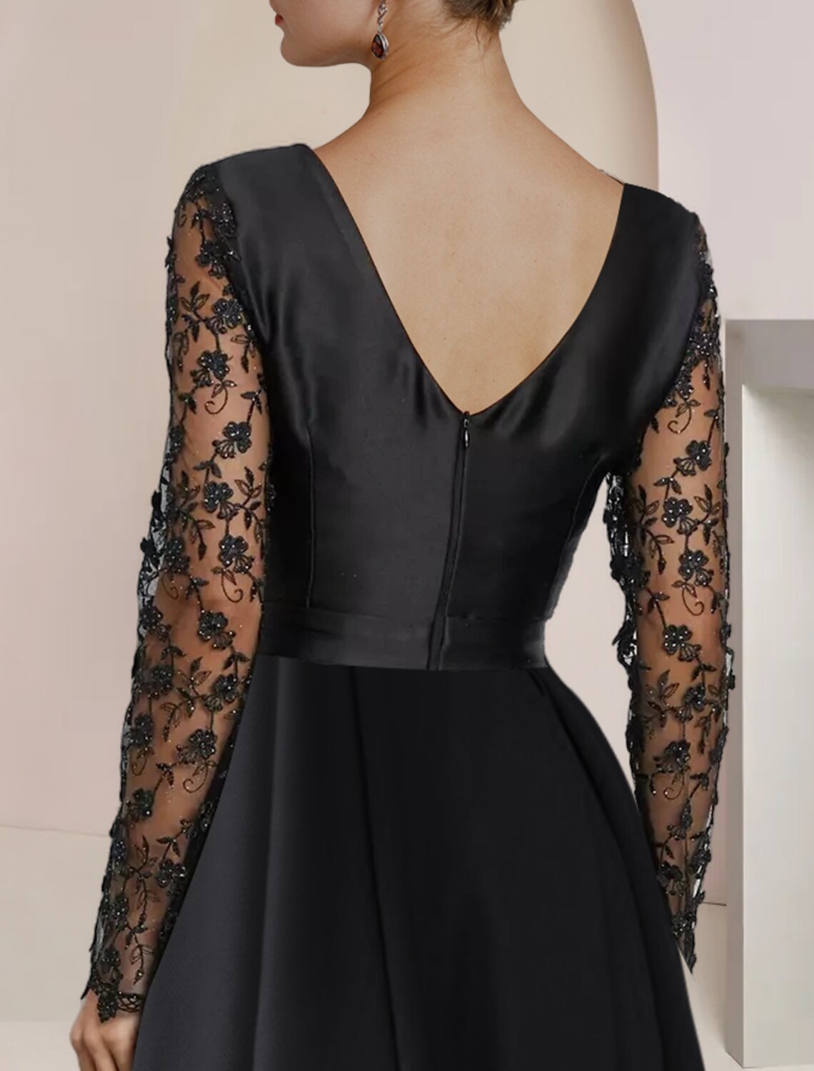 Back view of an elegant long sleeve dress with intricate lace details.
