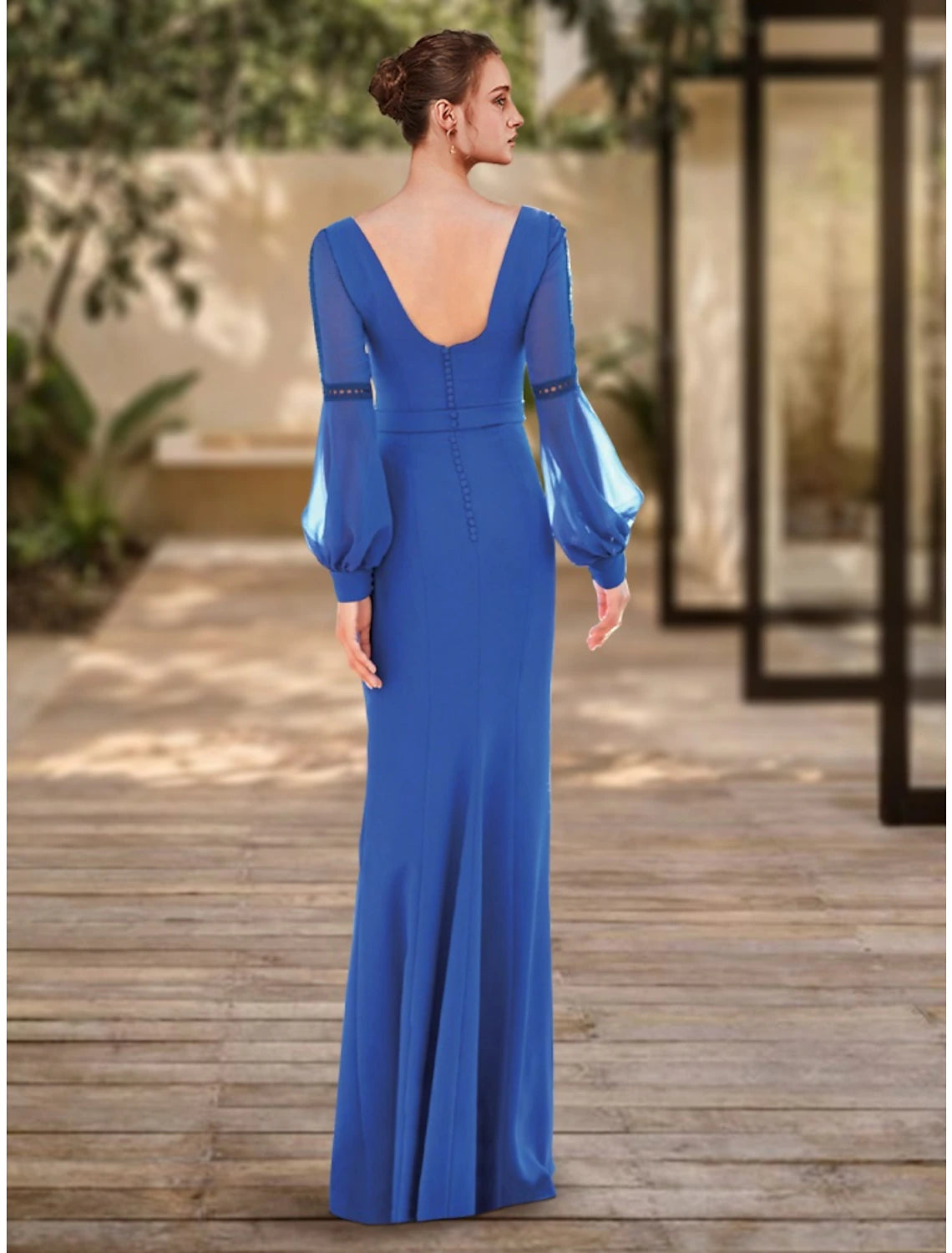 Woman wearing a formal floor-length sheath column dress with long sleeves, side view.