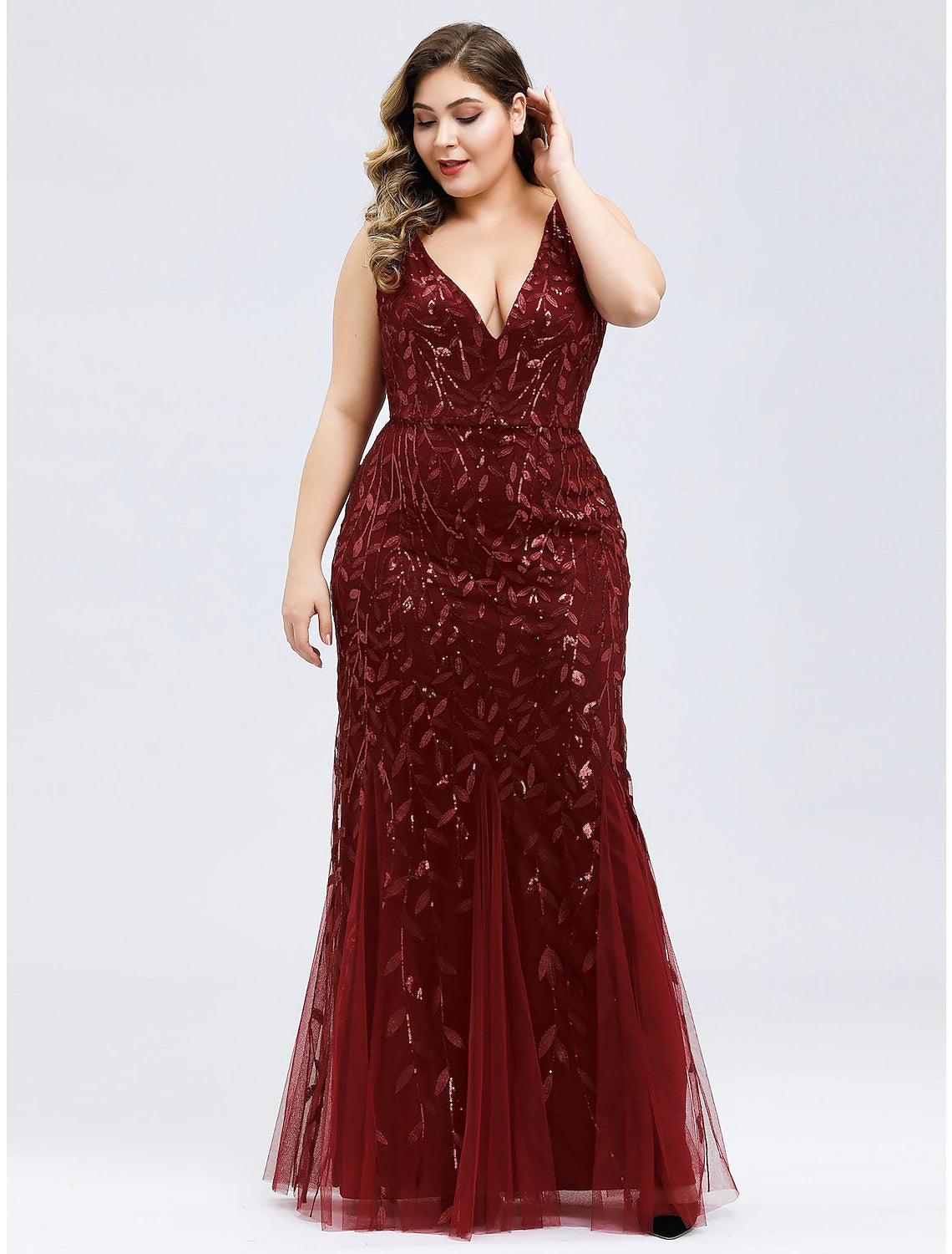 Side profile of a woman wearing a sleeveless mermaid trumpet dress.
