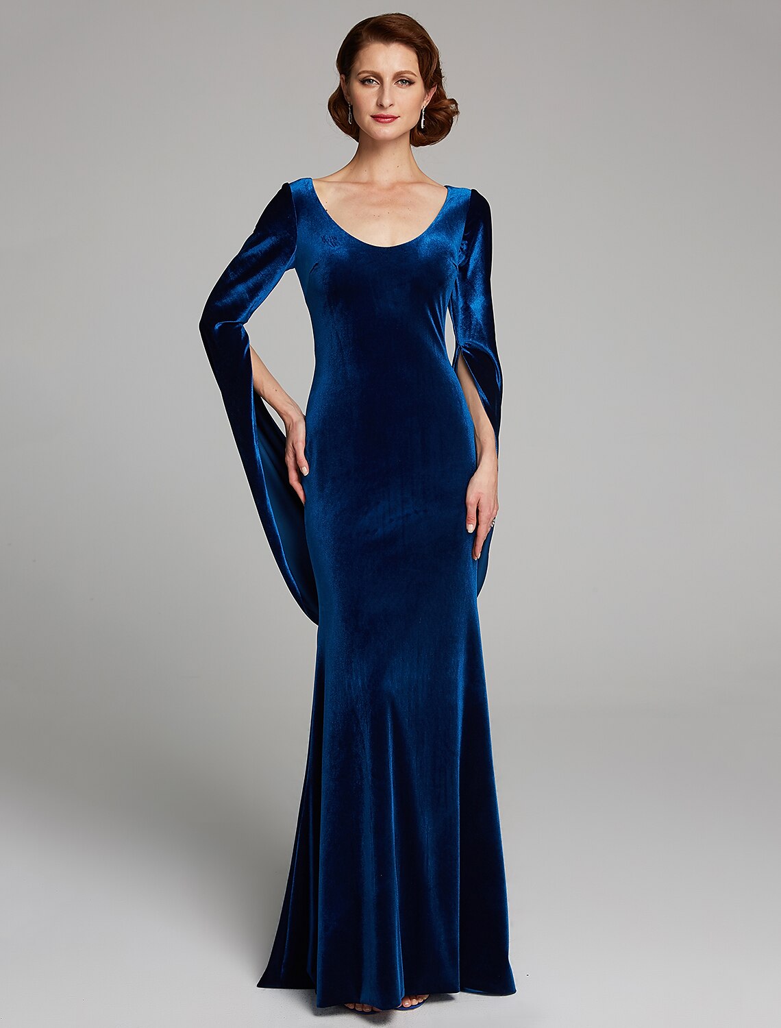 Woman in an elegant velvet mermaid mother of the bride dress with long sleeves and scoop neck.