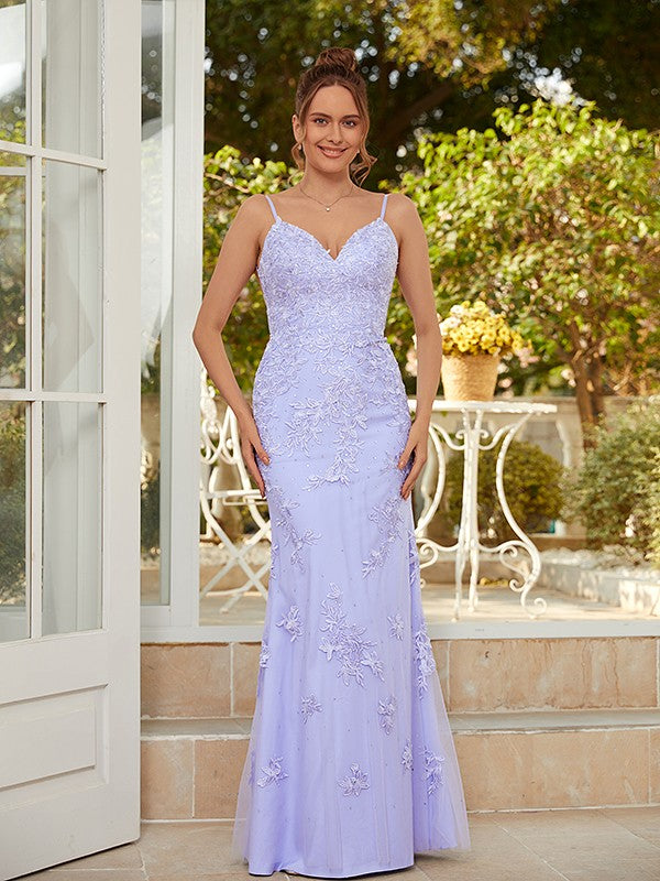 Woman wearing a light blue sheath column tulle applique V-neck floor-length prom dress.