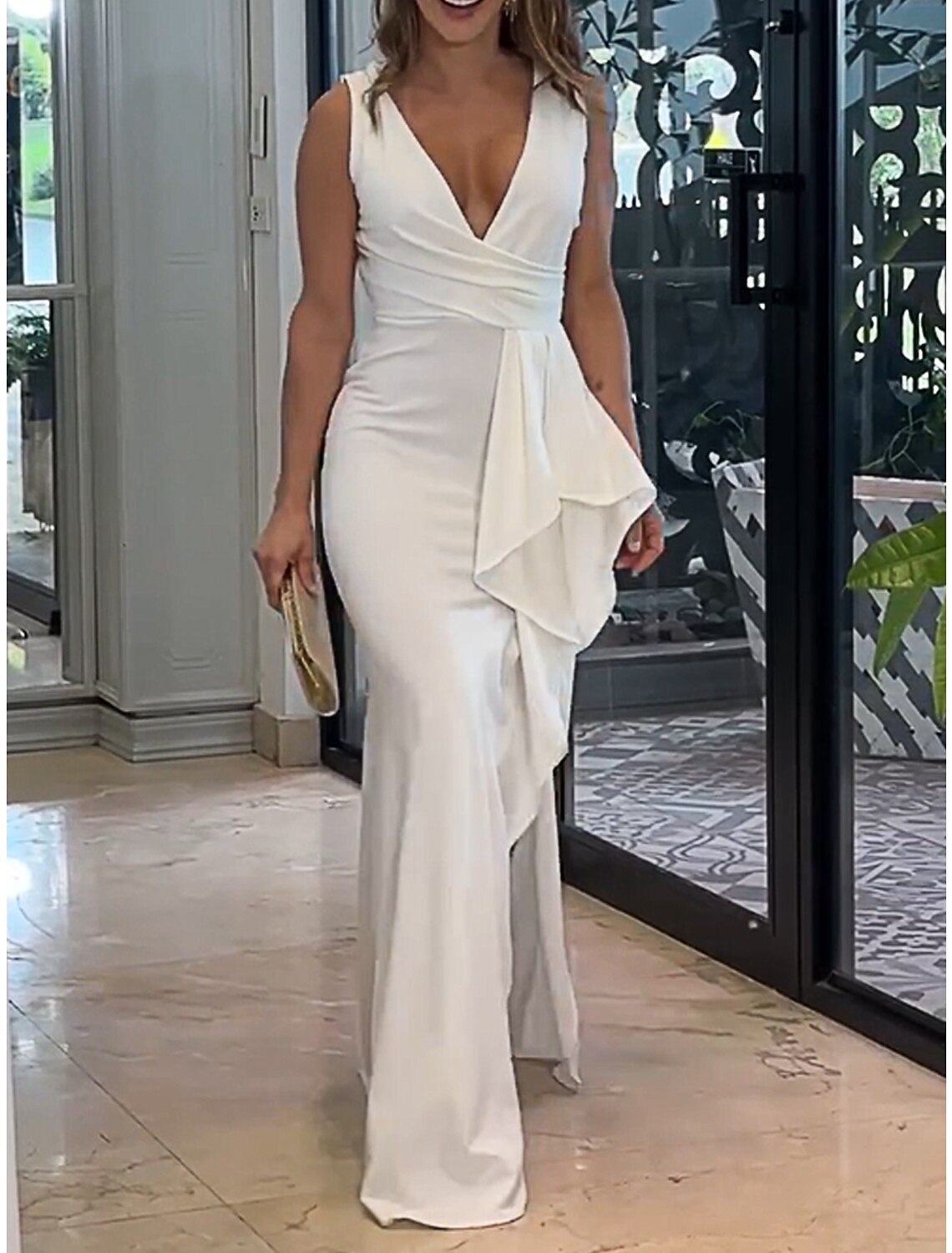Model wearing a white V-neck ruffle maxi dress.