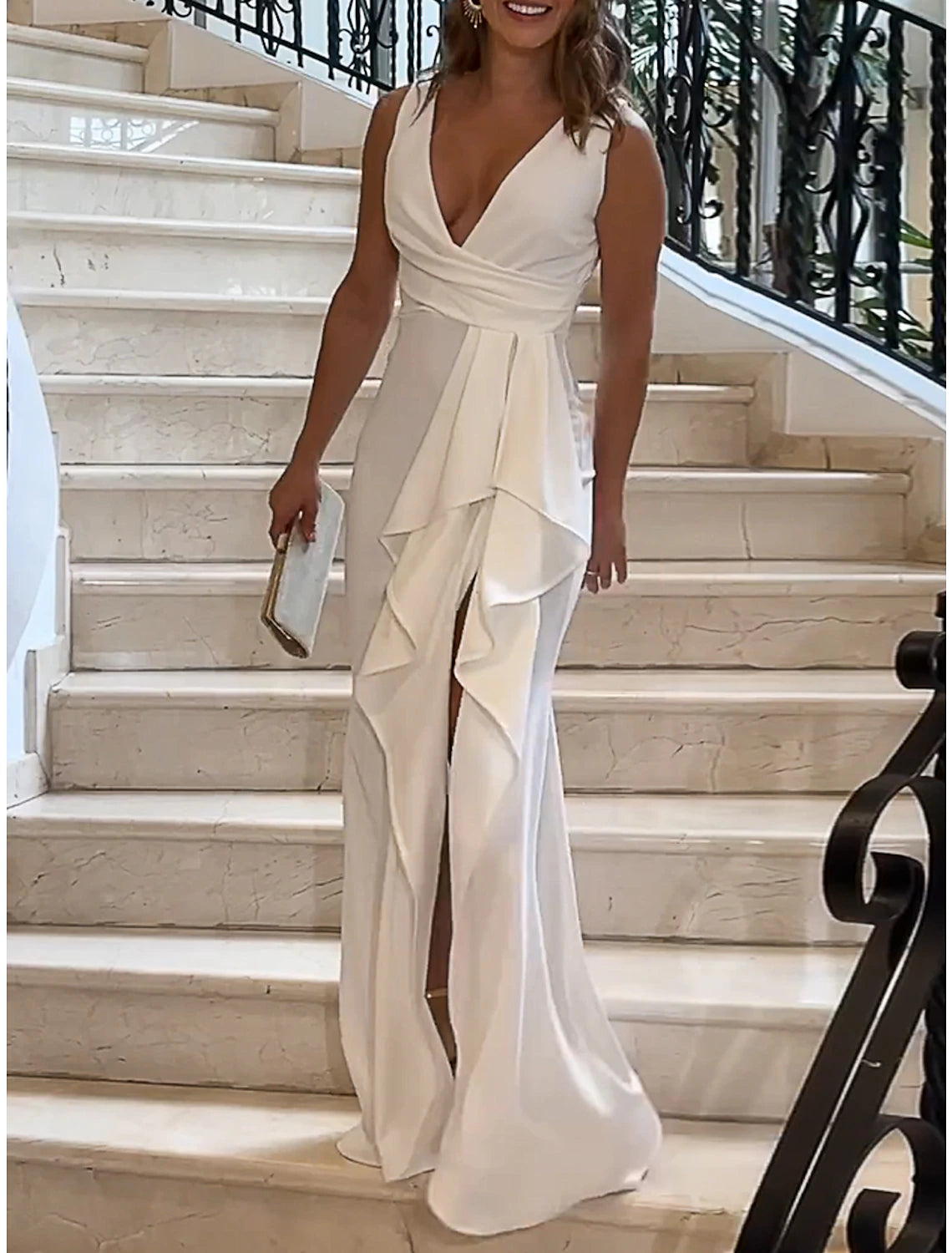 Close-up of the ruffle detail on a white V-neck maxi dress.