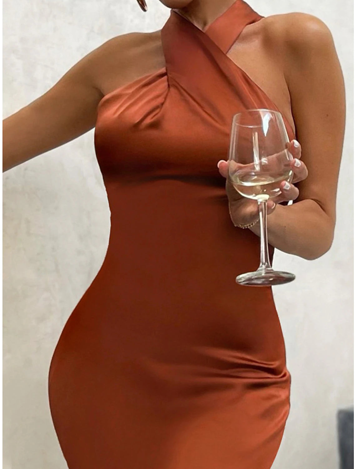 Woman in a green halter neck sleeveless maxi dress.