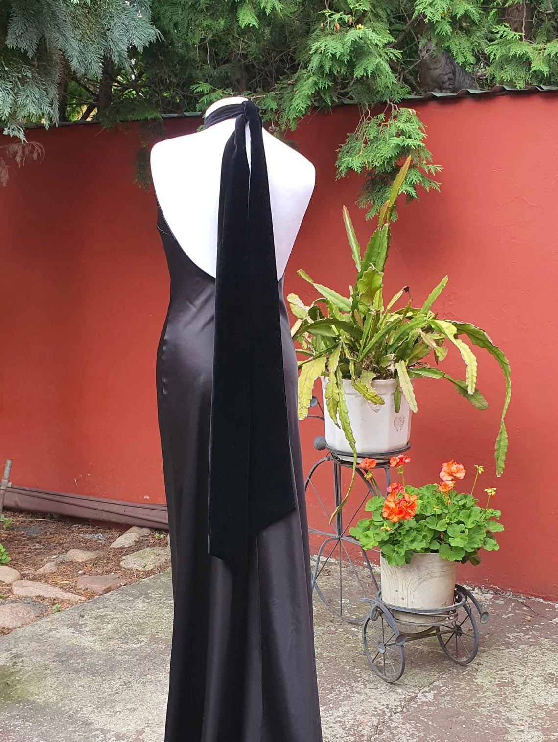 Elegante vestido de fiesta de dama de honor negro sin mangas con cuello halter, espalda descubierta y corte sirena, largo hasta el suelo 