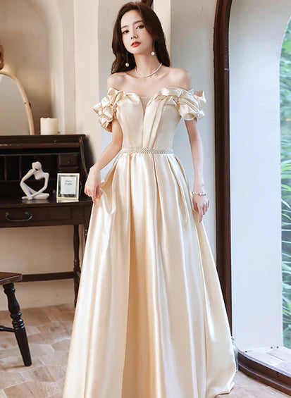 Vestido de fiesta largo con volantes y hombros descubiertos en satén color champán hasta el suelo