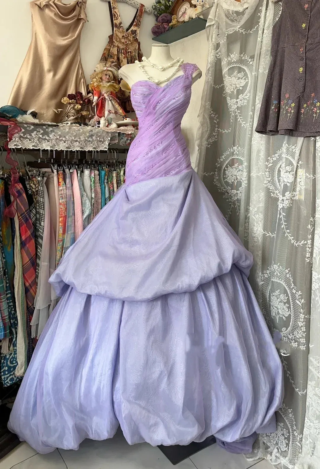 Lavender one-shoulder tulle ball gown with a tiered skirt and low back.