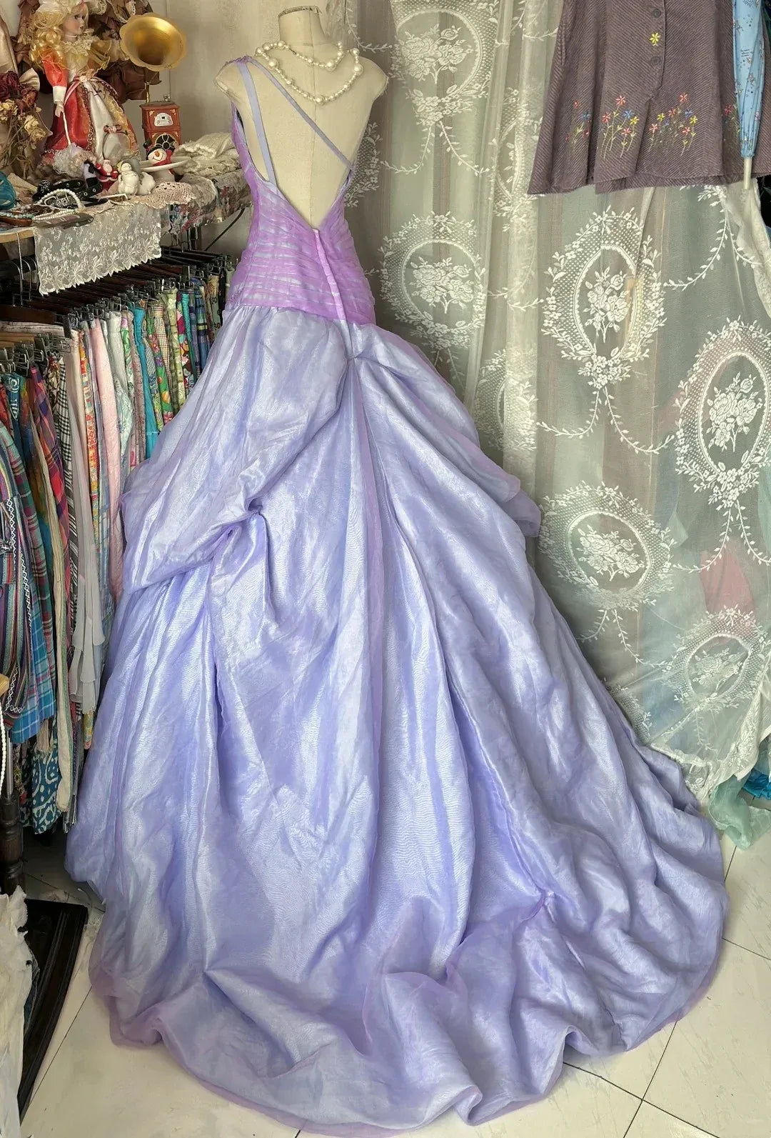 Back view of the lavender one-shoulder ball gown showing the low back and tiered skirt.