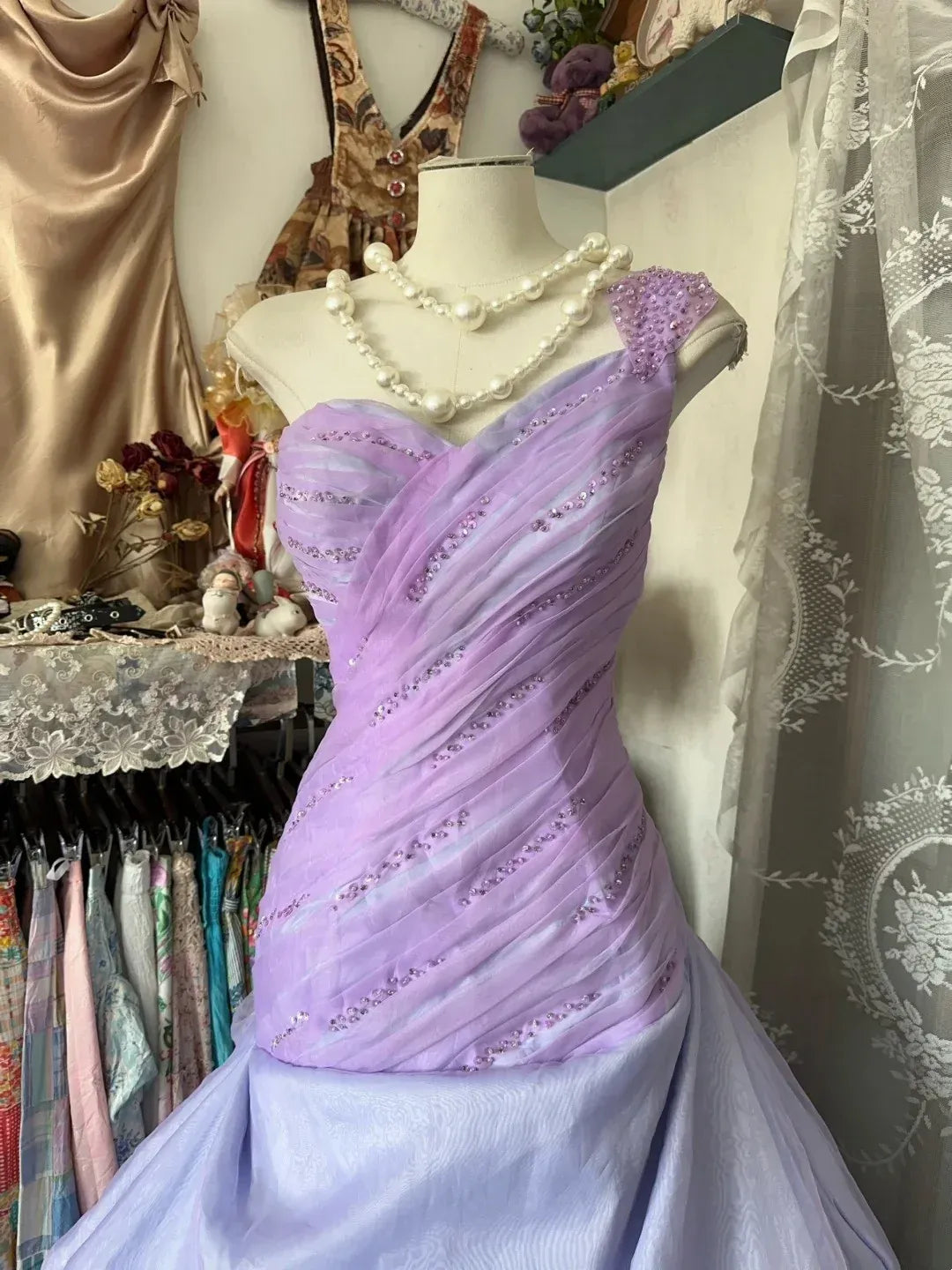 Close-up of the sparkling ruched bodice and one-shoulder detail of the lavender gown.