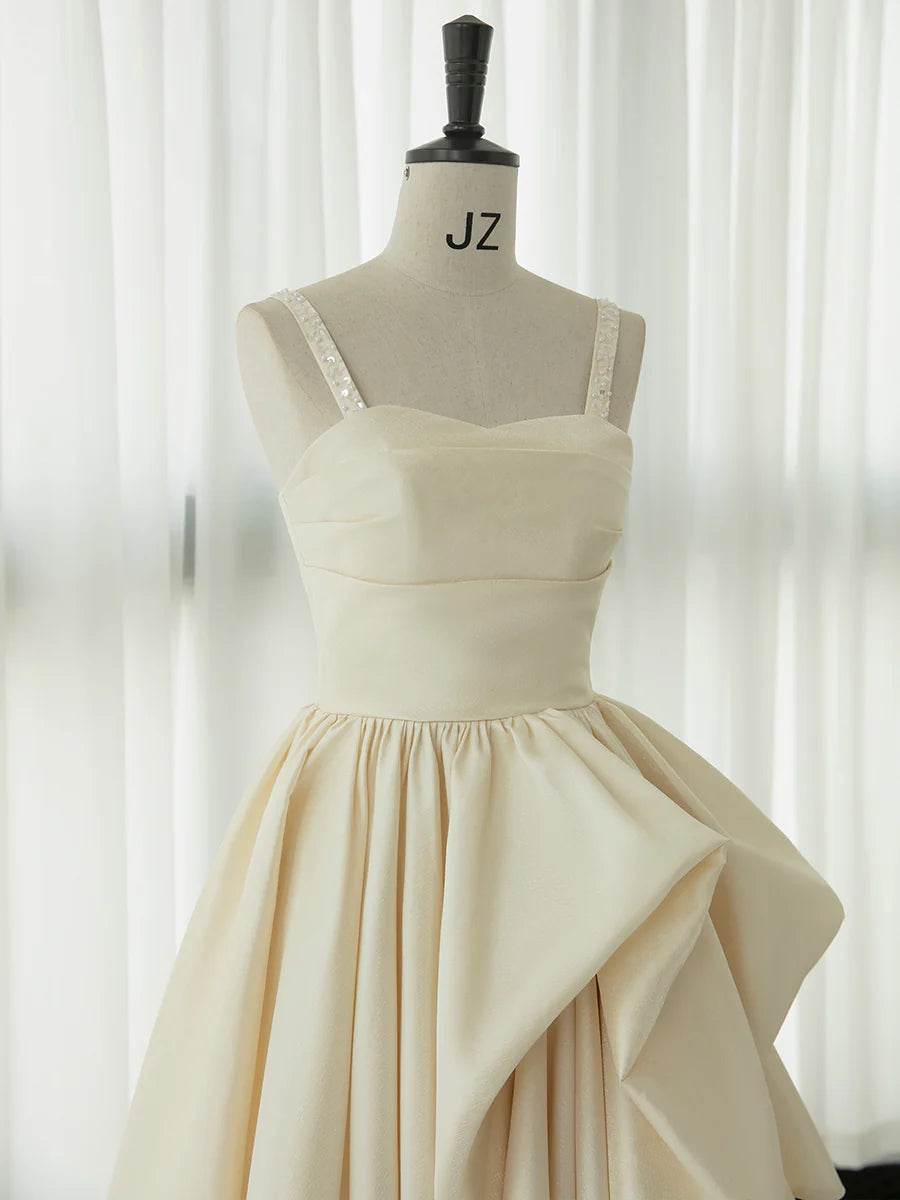 Vestido de fiesta de satén color champán con tirantes finos y volantes hasta la rodilla