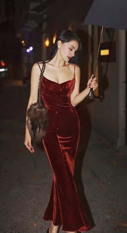 Hermoso vestido de fiesta de noche con tirantes finos y hombros descubiertos, de terciopelo rojo. 