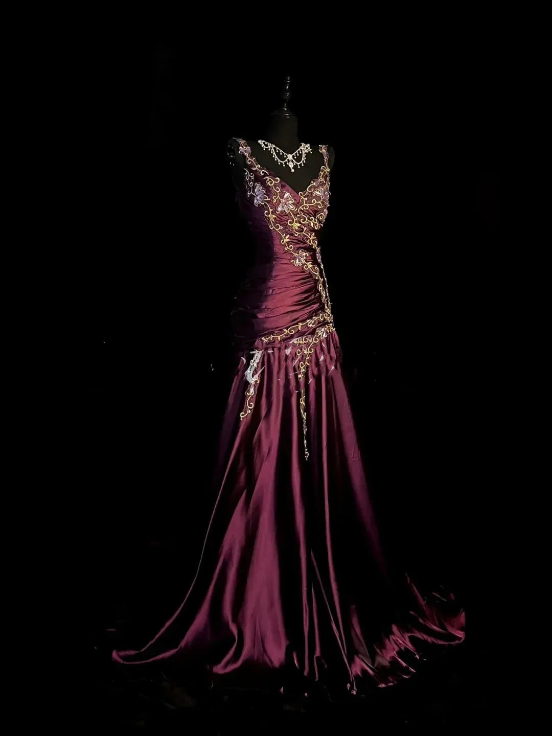 Close-up of plum mermaid dress bodice with V-neck and floral details.