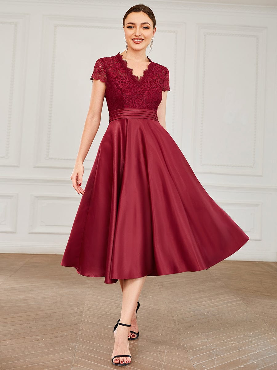 Model posing in a burgundy Weitese V-neck lace dress, showing the full length and flow.