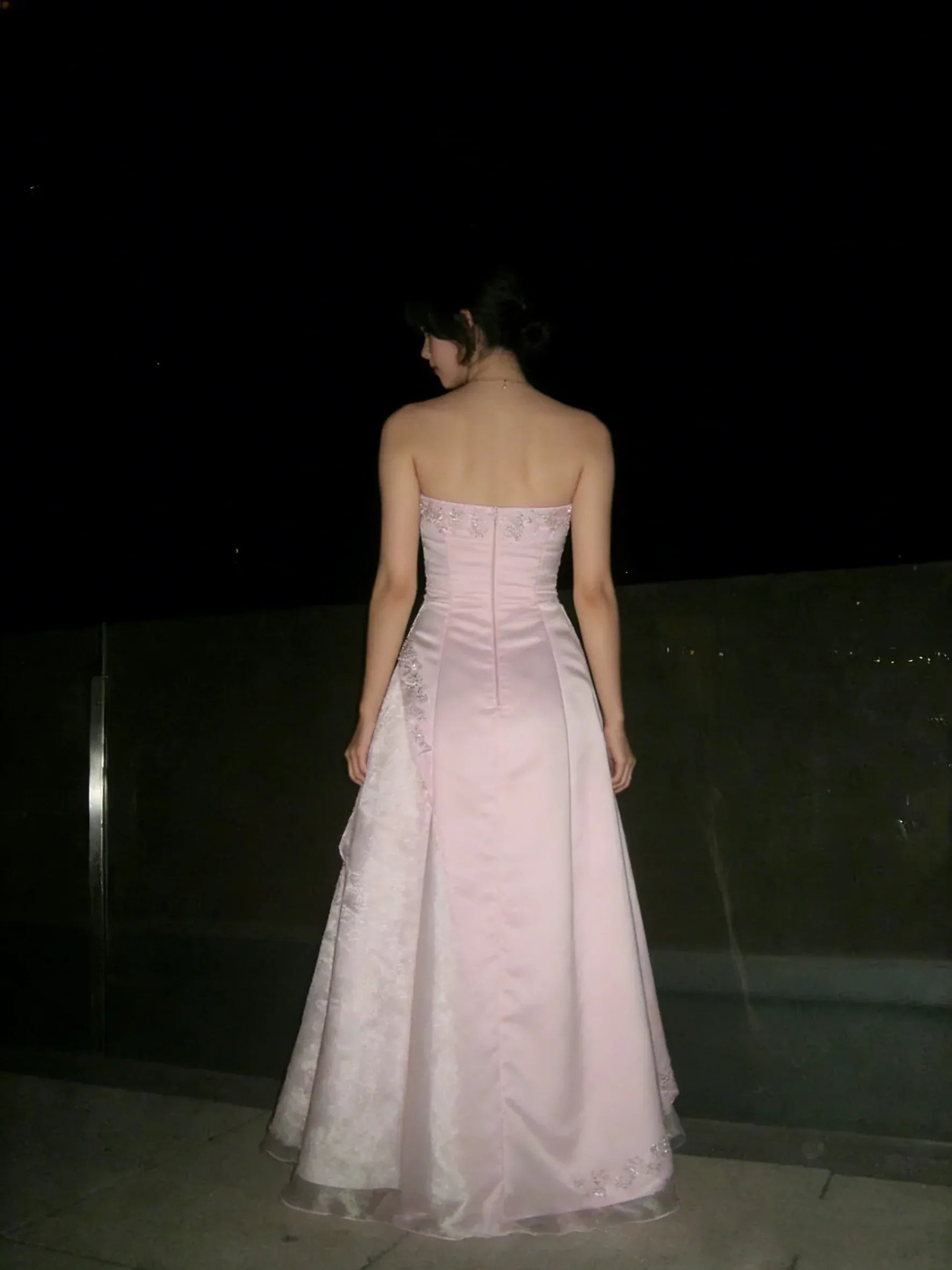 Close-up of the delicate embroidery on the bodice and flowing A-line skirt of the pink ball gown.