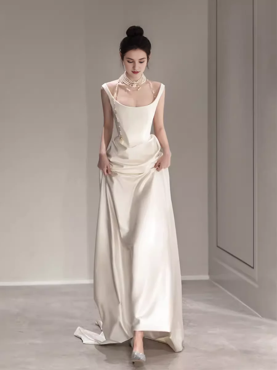 Vestido de noche blanco sencillo de corte sirena, largo hasta el suelo, sin mangas y con hombros descubiertos 