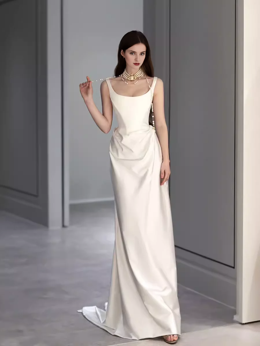 Vestido de noche blanco sencillo de corte sirena, largo hasta el suelo, sin mangas y con hombros descubiertos 