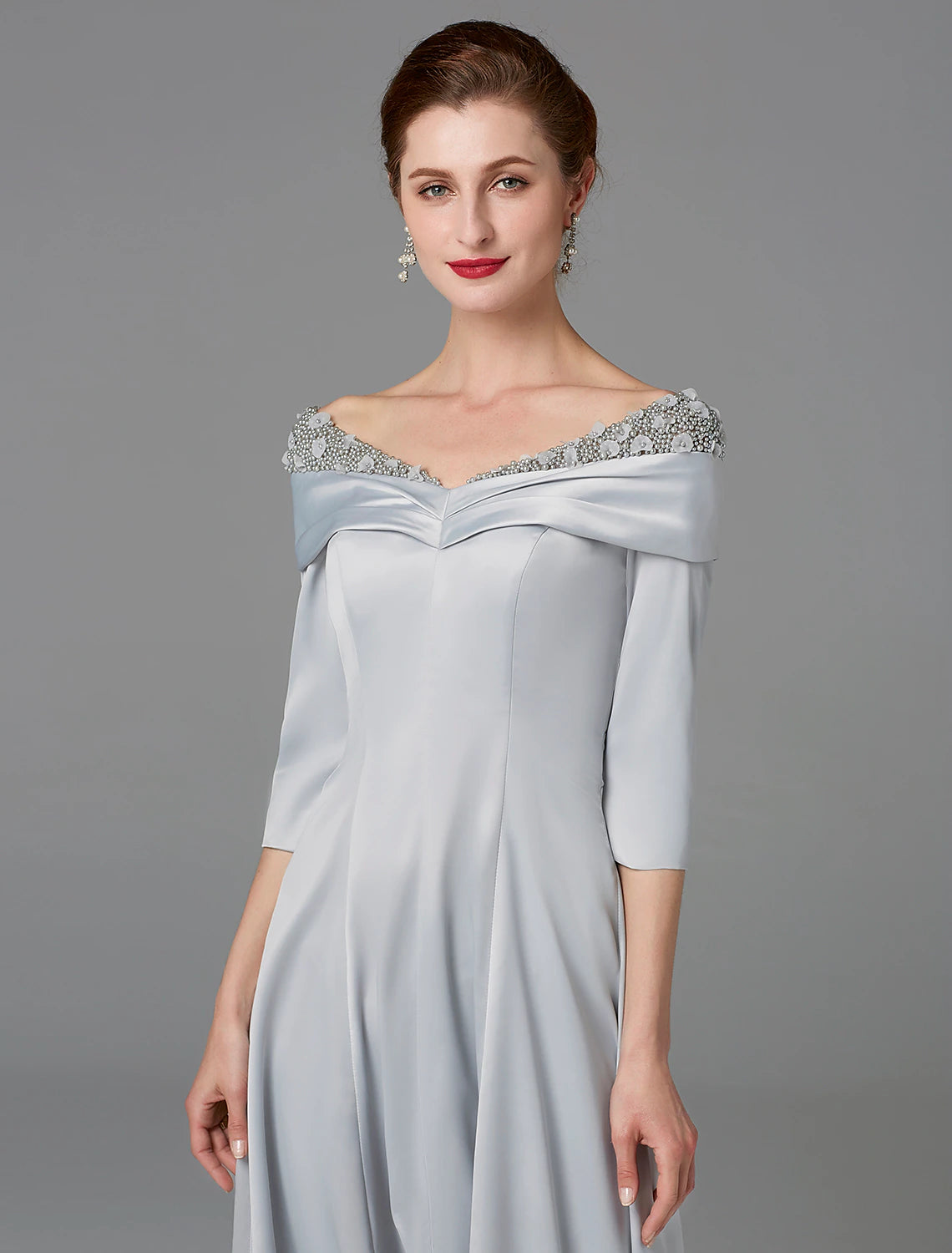 Full length view of the woman in the sparkling satin A-line dress, posing gracefully.